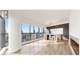 A spacious room with a desk and a view of the city through the windows.