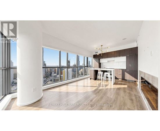 A spacious room with a desk and a view of the city through the windows.