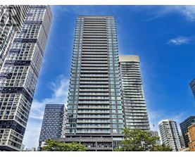 A tall building with many windows stands in front of other buildings.