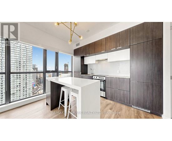 A modern kitchen with dark wood cabinets and a white island.