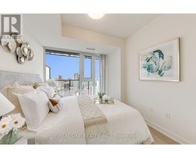 A bedroom with a large bed and a view of the city through the window.