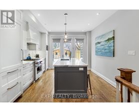 A kitchen with white cabinets and a wooden floor.