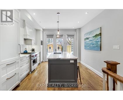 A kitchen with white cabinets and a wooden floor.