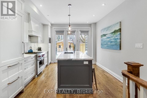 A kitchen with white cabinets and a wooden floor.