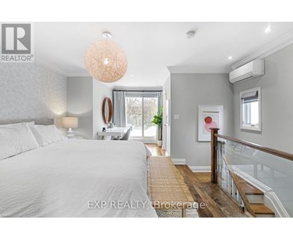 A bedroom with a large bed and a staircase.