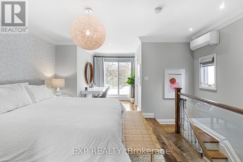 A bedroom with a large bed and a staircase.
