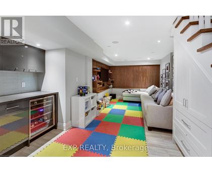 A living room with a white couch and a colorful rug.