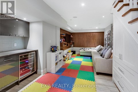 A living room with a white couch and a colorful rug.