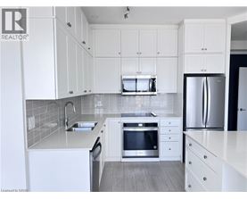 A modern kitchen with white cabinets and stainless steel appliances.