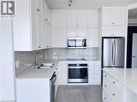 A modern kitchen with white cabinets and stainless steel appliances.