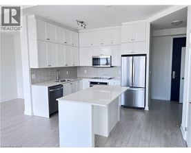 A modern kitchen with white cabinets and stainless steel appliances.