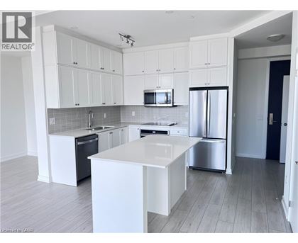 A modern kitchen with white cabinets and stainless steel appliances.