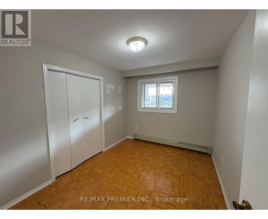A room with a window and a wooden floor.
