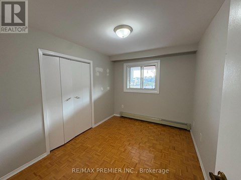 A room with a window and a wooden floor.