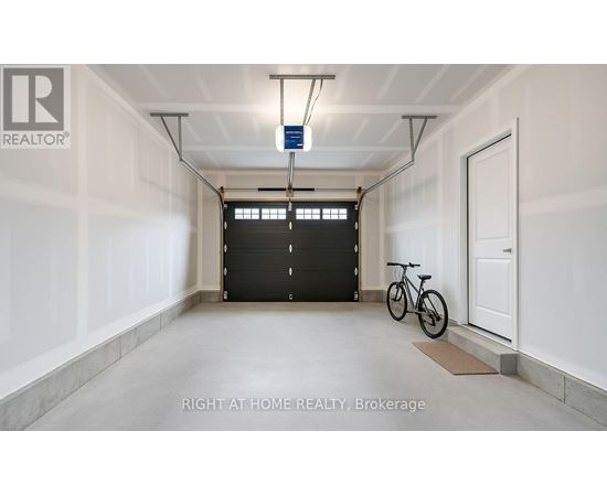 A spacious garage with a bicycle and a black door.