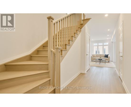 A wooden staircase leads to a bright living room.
