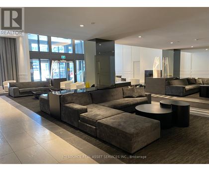 A large, modern living room with a grey sofa set and a black coffee table.