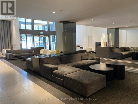 A large, modern living room with a grey sofa set and a black coffee table.