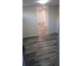 A hallway with a wooden floor and white walls.