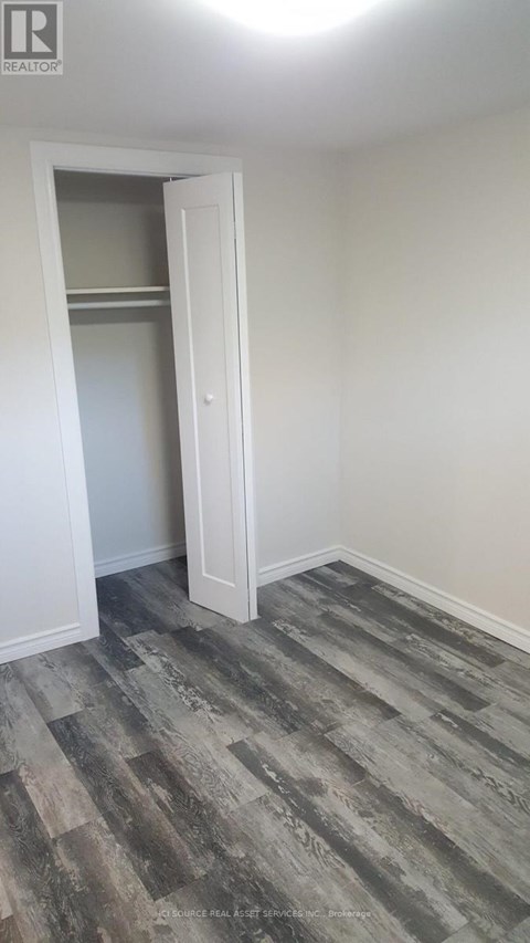 A room with a wooden floor and a white door.