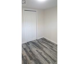 A room with a white door and a wooden floor.