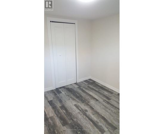 A room with a white door and a wooden floor.