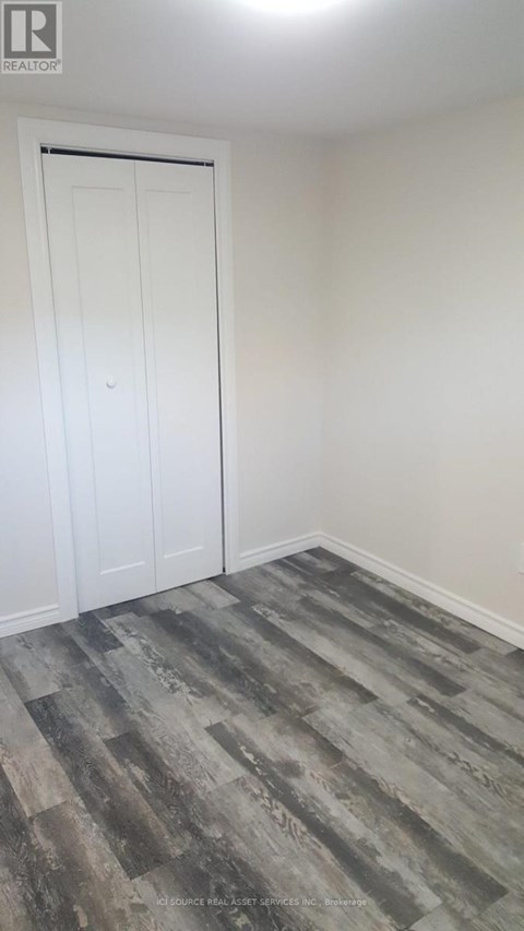 A room with a white door and a wooden floor.