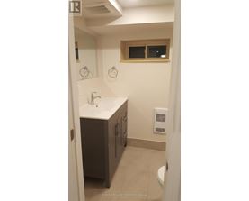 A bathroom with a sink, mirror, and toilet.