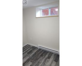A room with a window and wooden flooring.