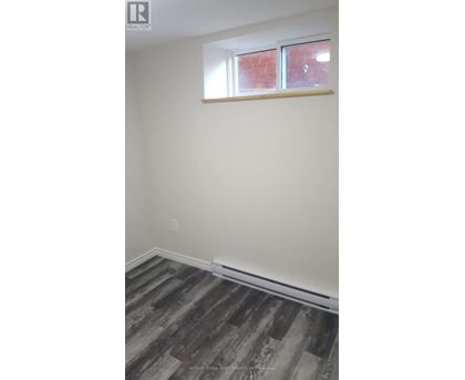 A room with a window and wooden flooring.