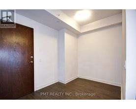 A room with a brown door and white walls.
