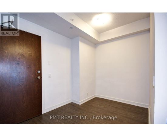 A room with a brown door and white walls.