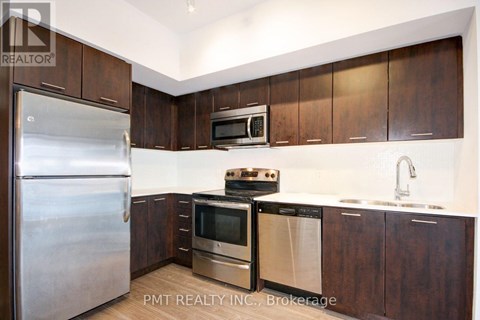 A kitchen with a stainless steel refrigerator, microwave, oven, and sink.