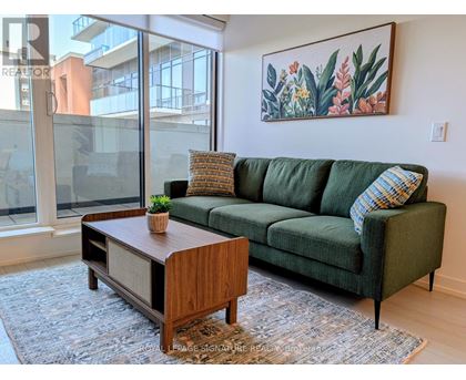 A living room with a green couch and a wooden coffee table.