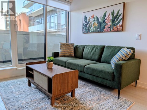 A living room with a green couch and a wooden coffee table.