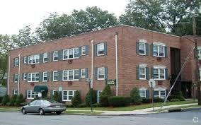 A brick building with a car parked in front.