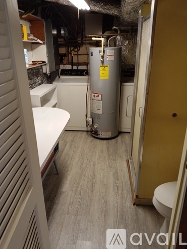 A small room with a toilet and a water heater.