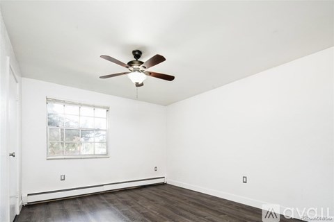 A room with a ceiling fan and a window.