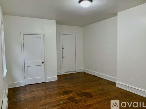 A room with two doors and a wooden floor.