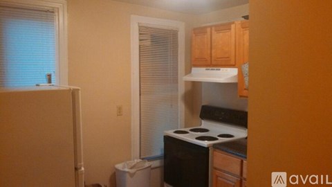 A kitchen with a white stove and wooden cabinets.