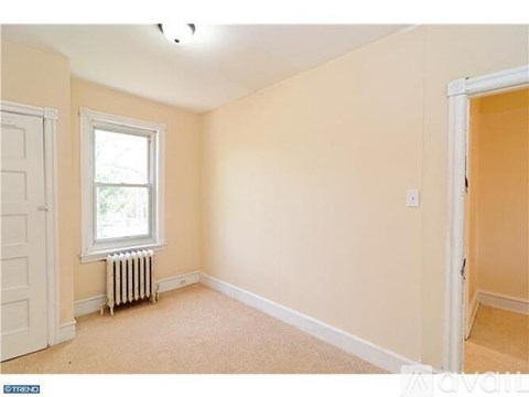 A room with a window and a radiator on the floor.