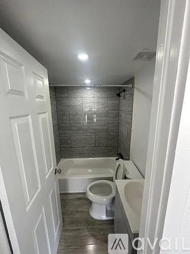 A bathroom with a white tub, toilet, and sink.