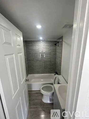 A bathroom with a white tub, toilet, and sink.