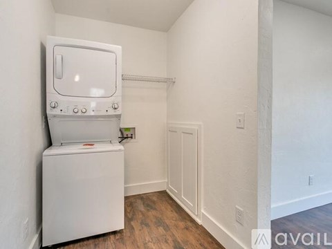 A white oven and stove top are in a small, empty room.
