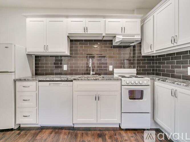 A kitchen with white appliances and cabinets.