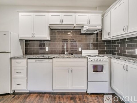A kitchen with white appliances and cabinets.