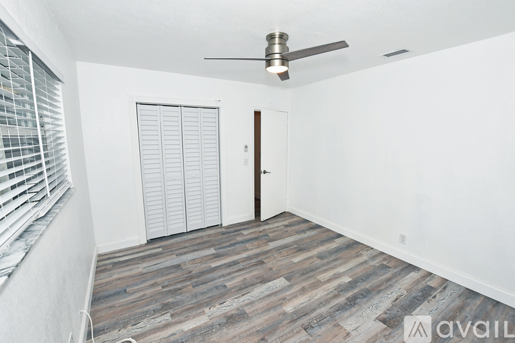 A room with a ceiling fan and a door.