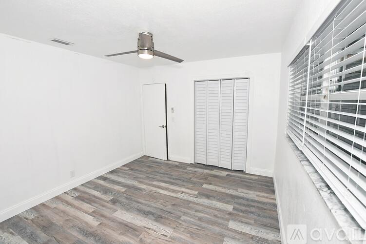 A room with a ceiling fan and a sliding door.