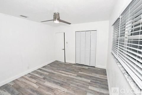 A room with a ceiling fan and a sliding door.