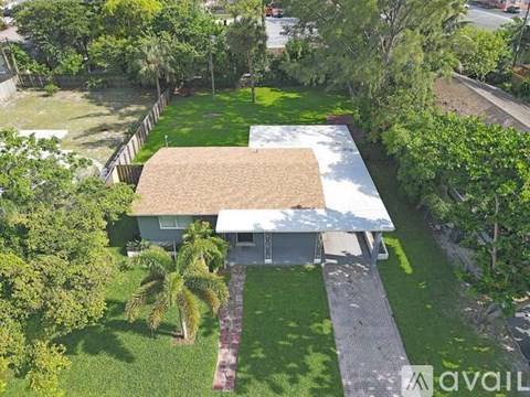 A house with a covered patio surrounded by greenery.